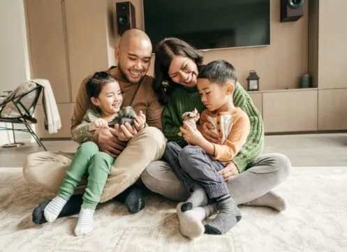 Family sitting together on a warm living room floor